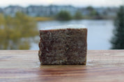 Block of sardine, beef, bison mix for cats against a blurred natural background.