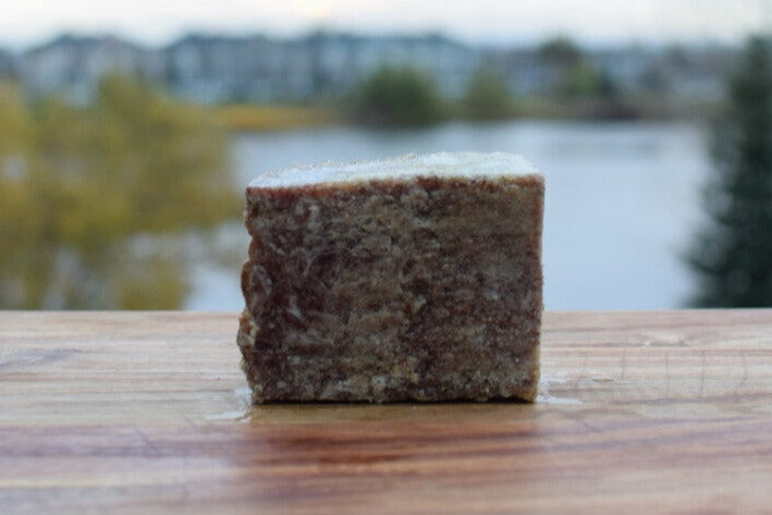 Block of sardine, beef, bison mix for cats against a blurred natural background.