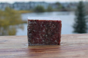 Sardine and chicken mix block on wooden surface, showcasing human-grade raw pet food made with quality ingredients.
