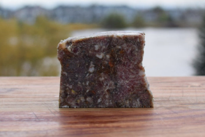 Raw pet food slice made from turkey, beef, bison, and vegetables, perfect for dogs and cats.