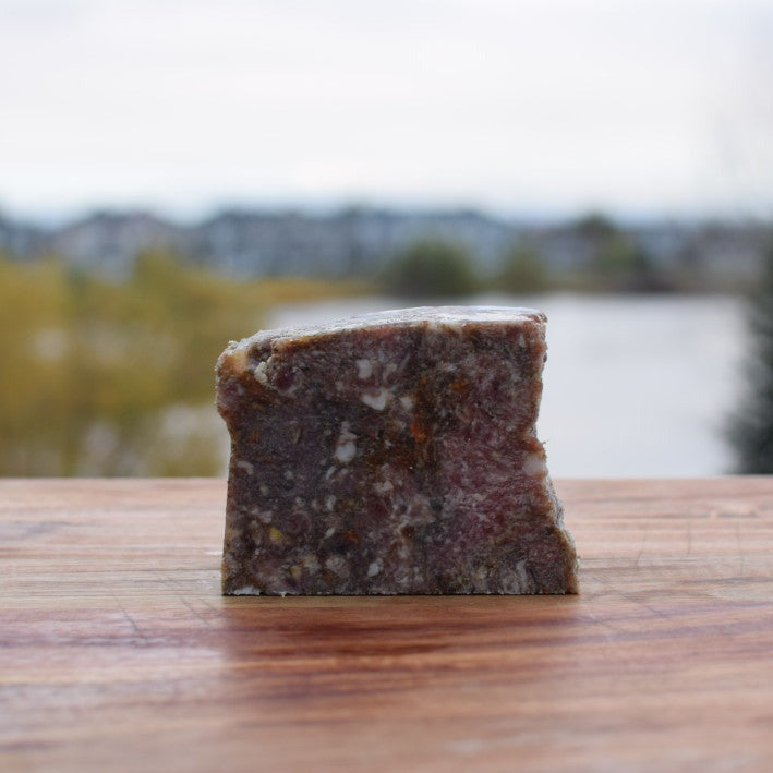 Raw pet food slice made from turkey, beef, bison, and vegetables, perfect for dogs and cats.